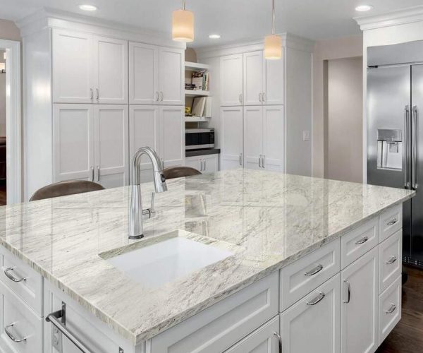 Marble kitchen countertop with grey veining beside fitted cabinetry