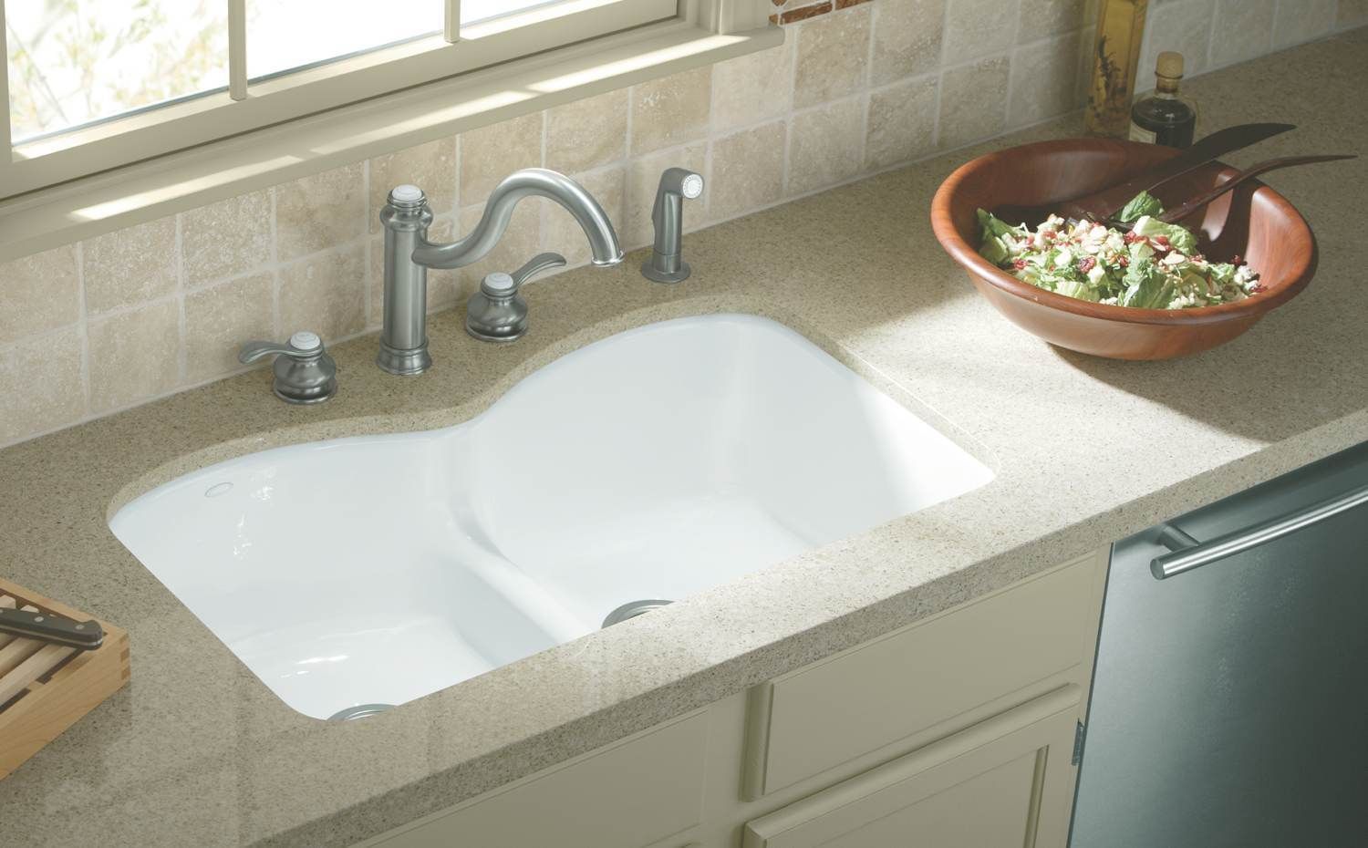 Undermount stainless steel sink set beneath a quartz countertop