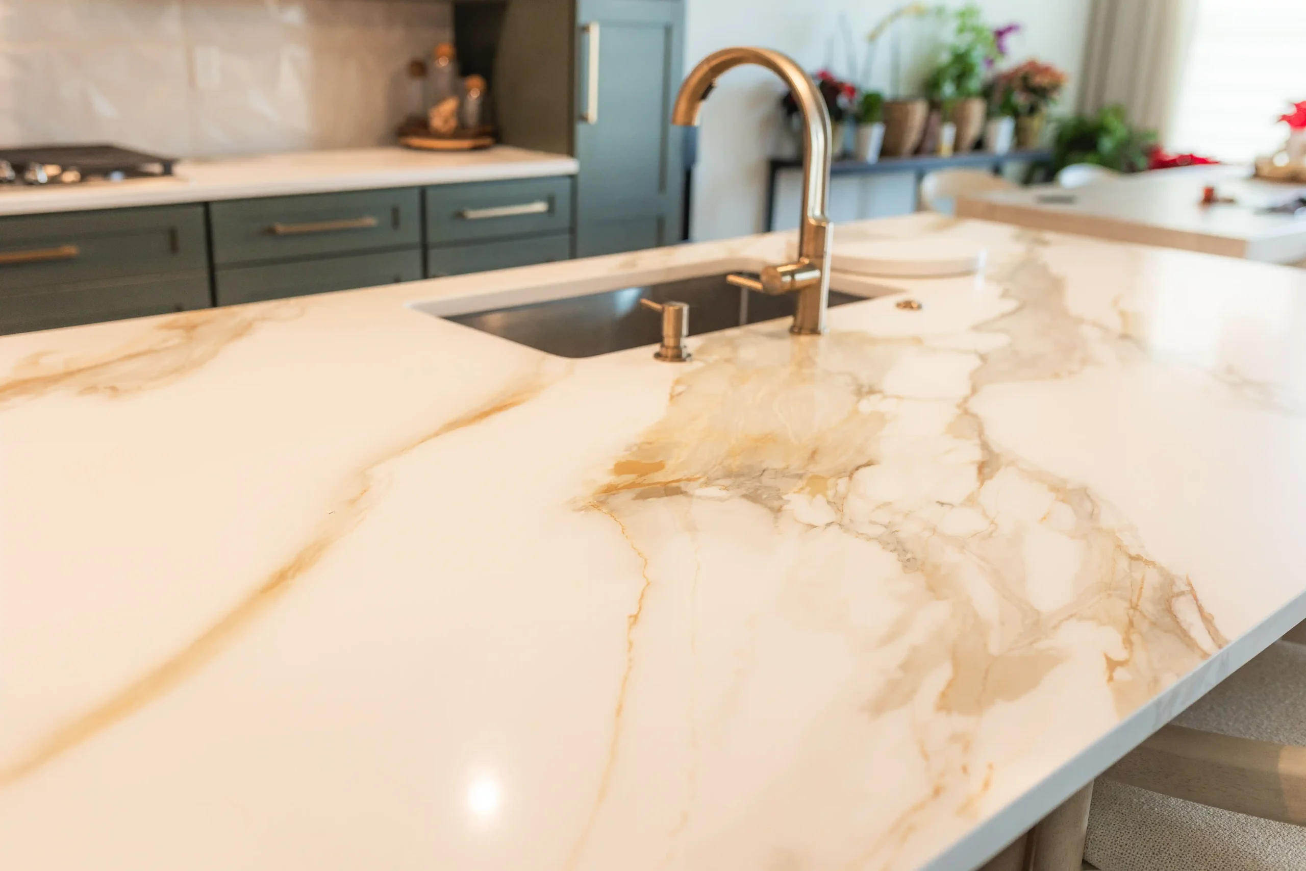 Quartz waterfall island and green shaker cabinetry in a completed Columbus kitchen