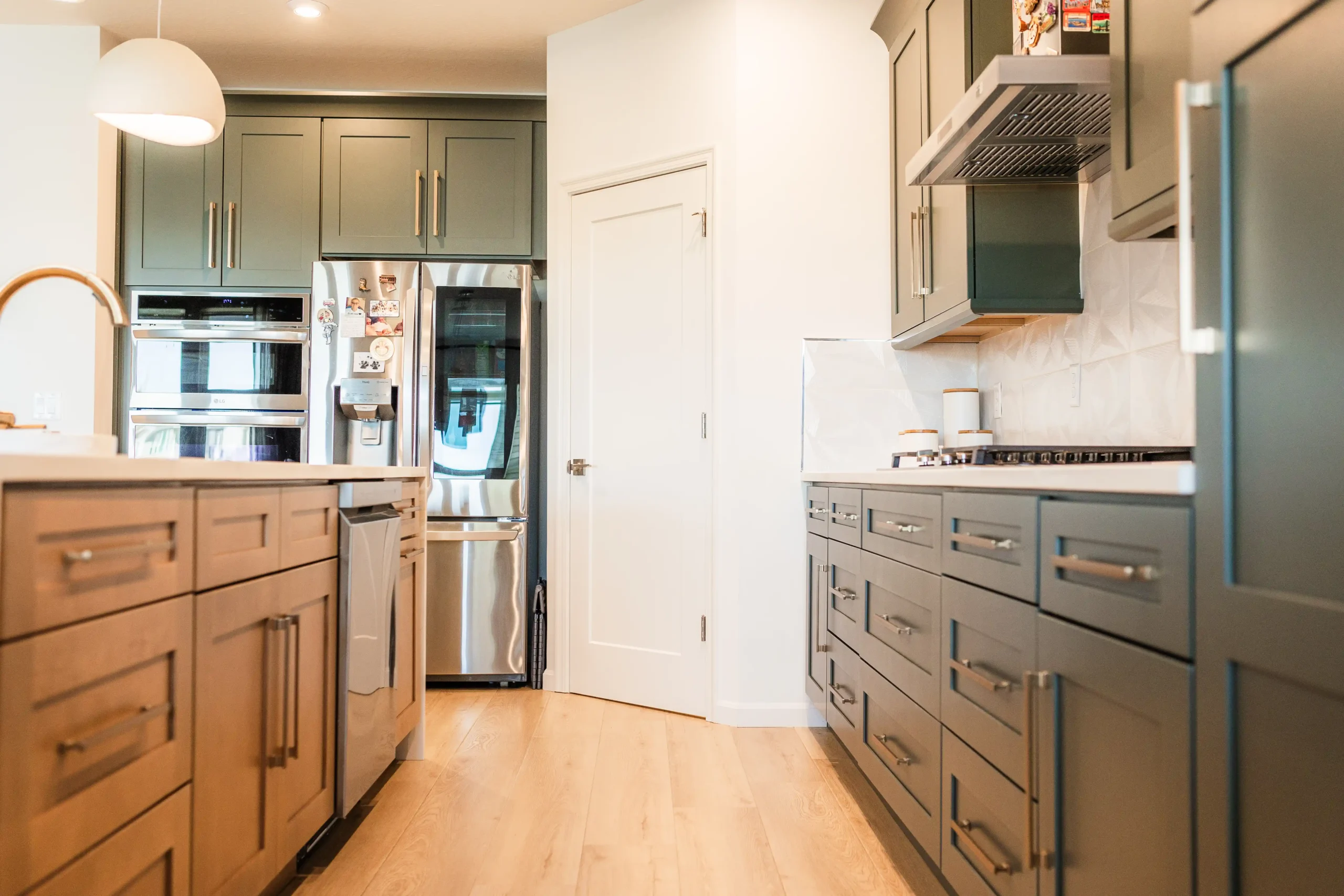 Wide-plank vinyl flooring running through a finished kitchen with fitted cabinetry